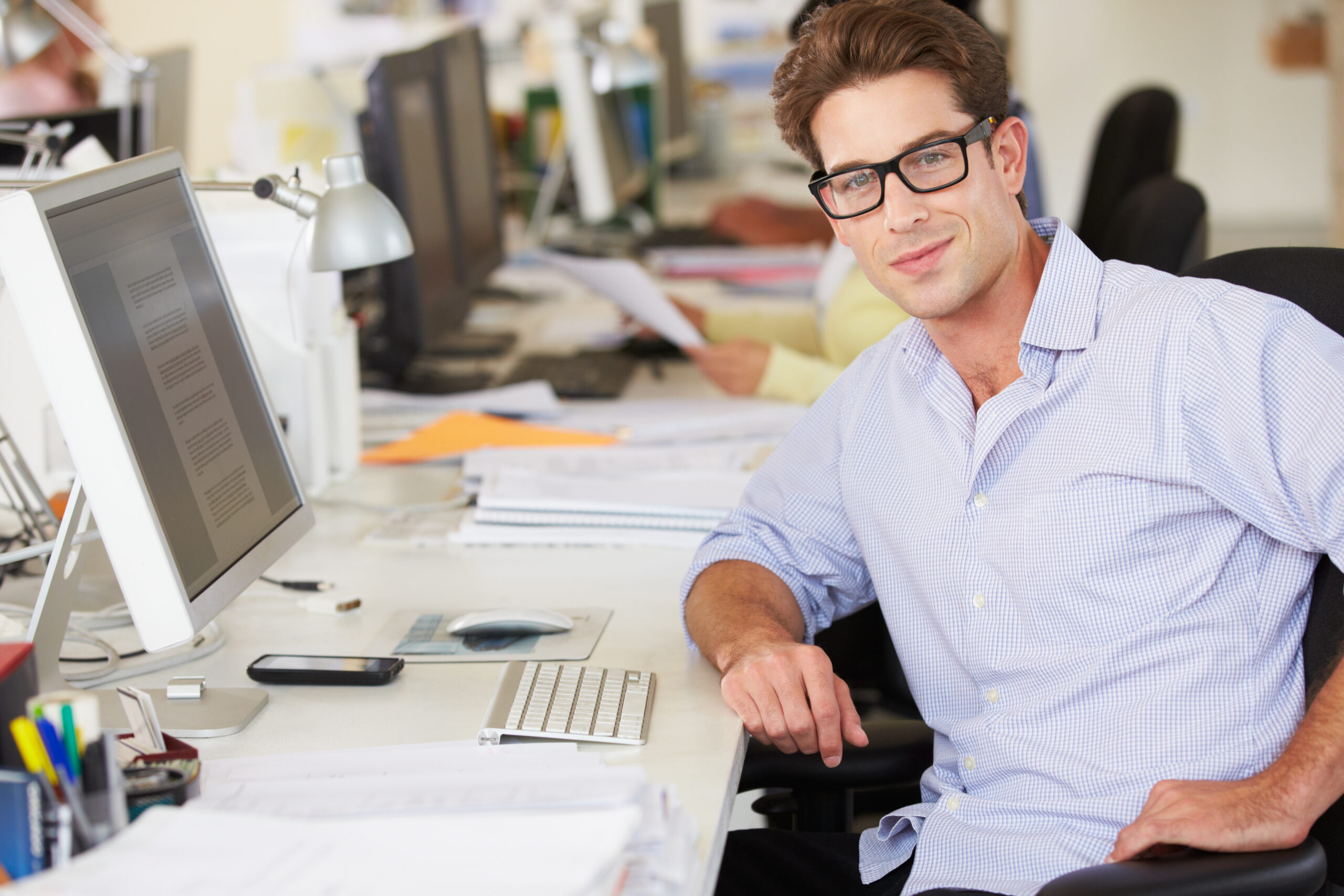 Man,Working,At,Desk,In,Busy,Creative,Office